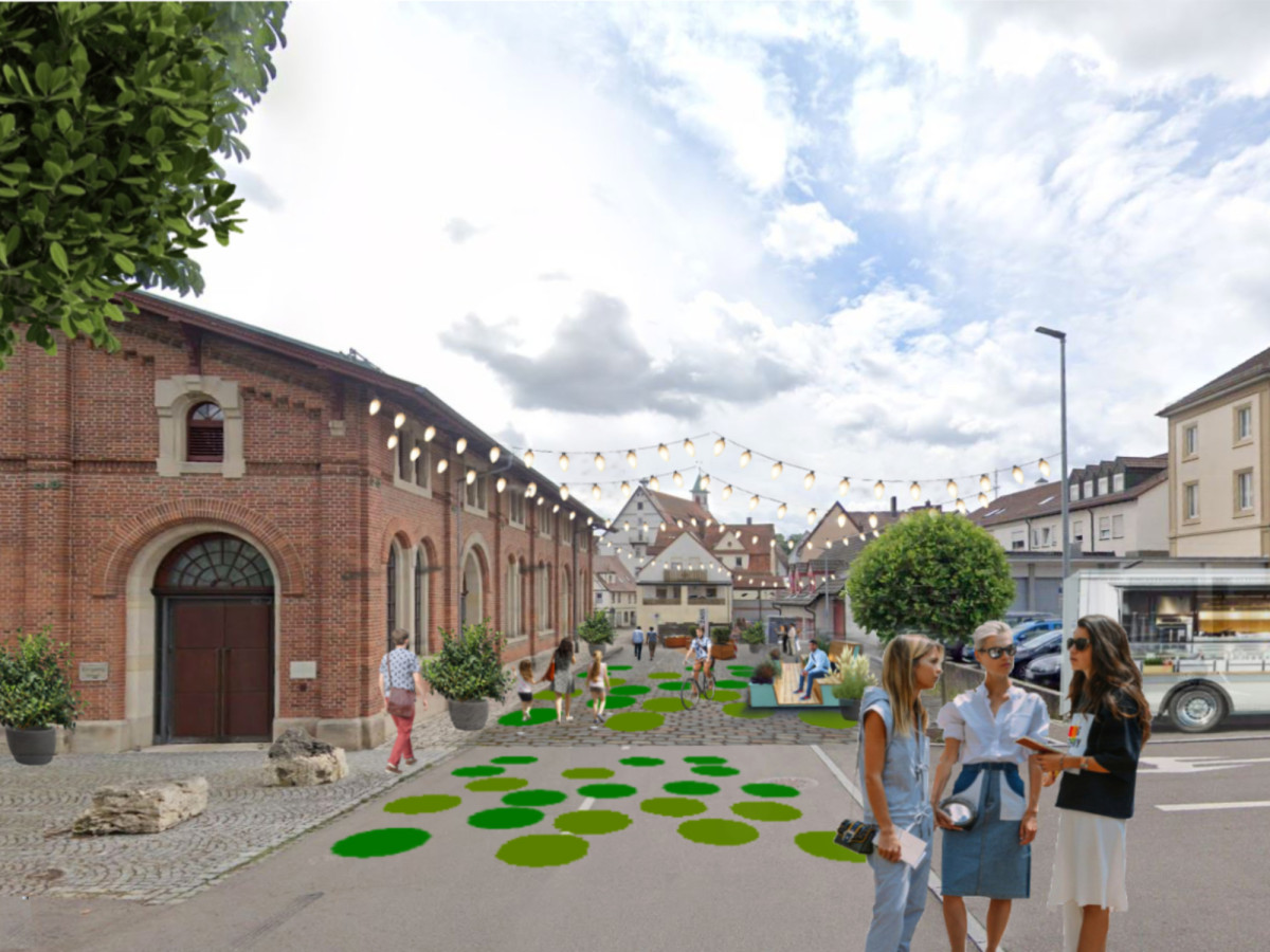 Umgestaltung der Obertorstra&szlig;e mit gr&uuml;nen Rundinseln, Ziegelbauwerk im Hintergrund und Fu&szlig;g&auml;ngern, die eine neu gestaltete urbane Platzumgebung mit Stra&szlig;enbeleuchtung und historischer Architektur erkunden.